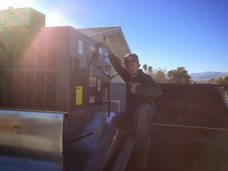 HVAC technician performing Air Duct Cleaning on a rooftop unit in Madera Ranchos