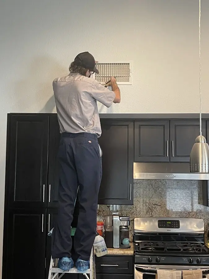 Technician inspecting an air vent during HVAC service in Madera Ranchos